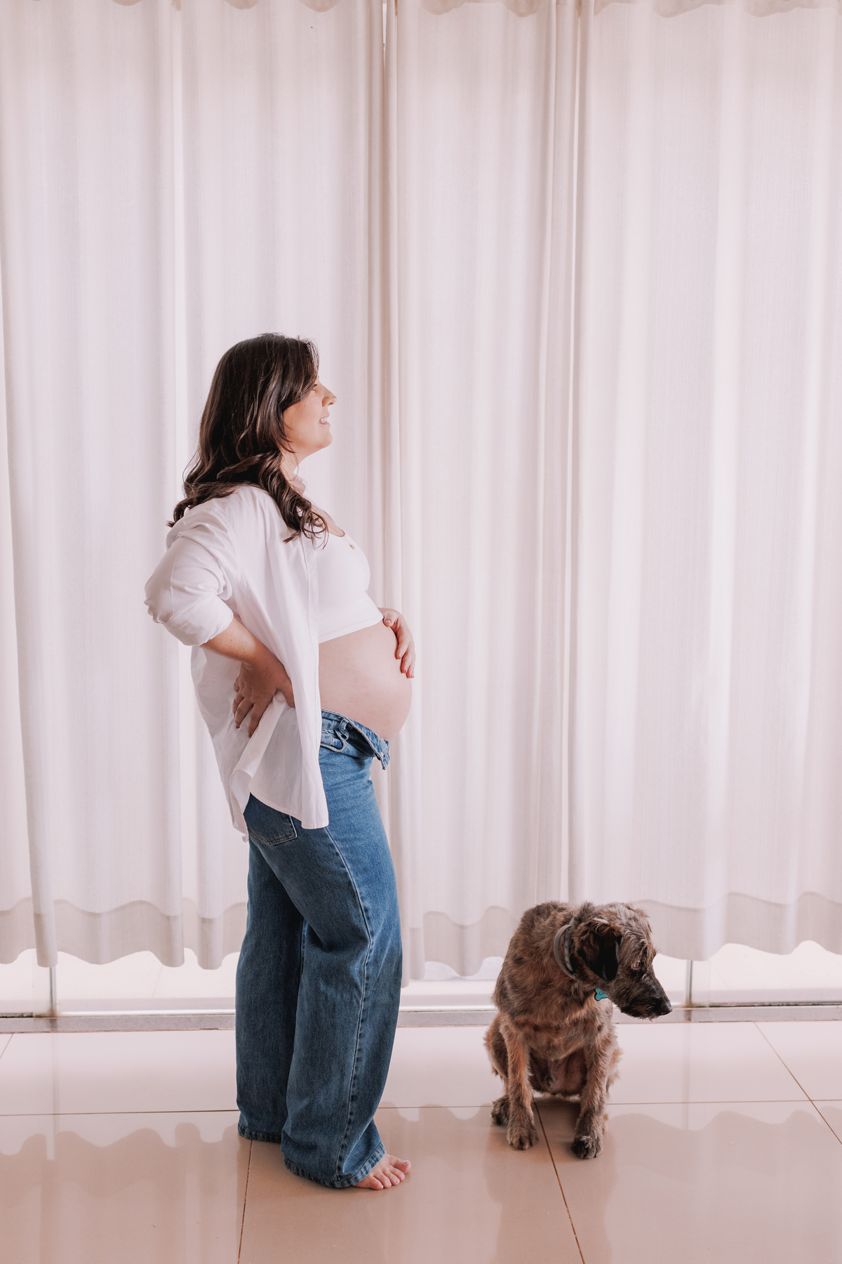 ensaio gestante em casa com pet calça jeans e camisa branca