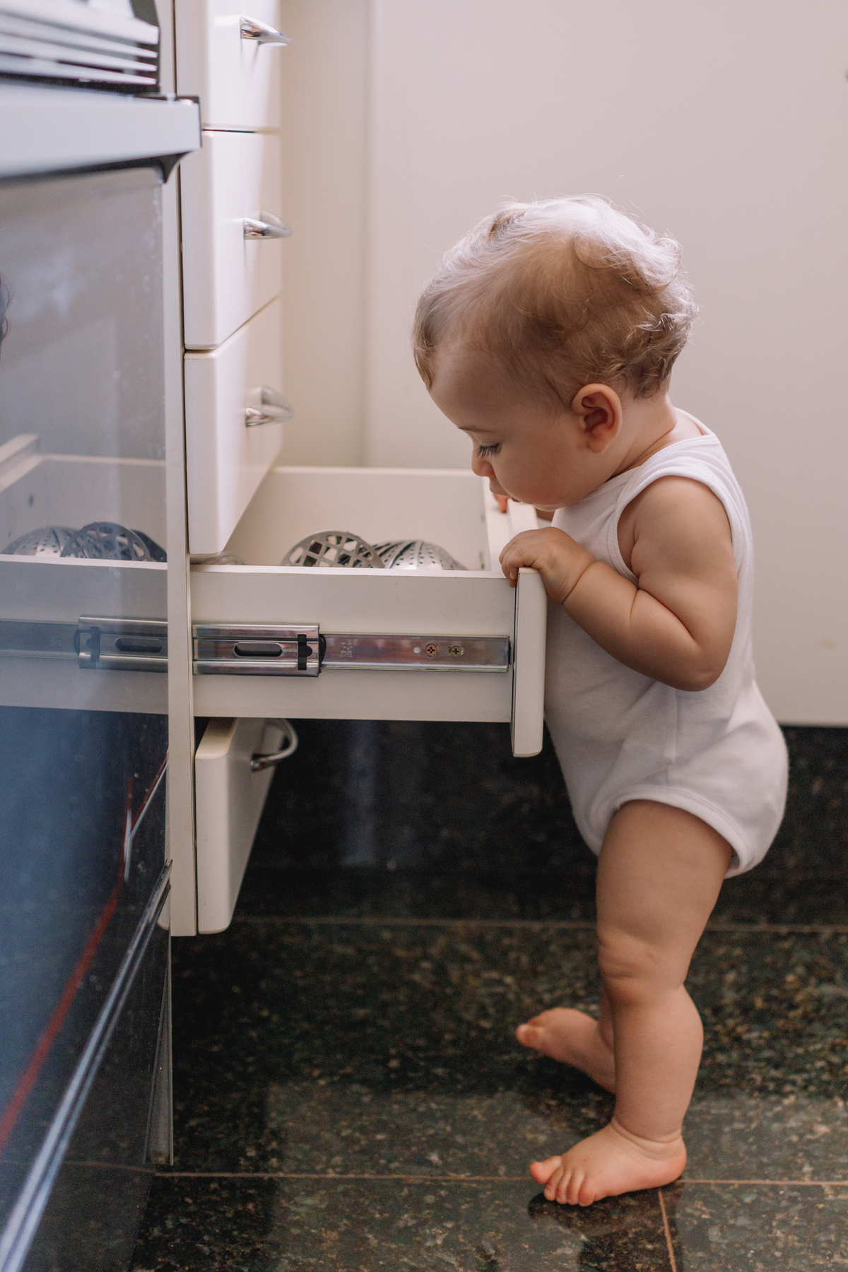 ensaio de bebe em casa tomando banho e brincando no quartinho abrindo gaveta da cozinha