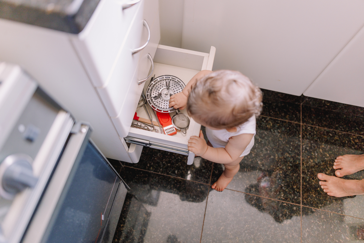 ensaio de bebe em casa tomando banho e brincando no quartinho abrindo gaveta da cozinha