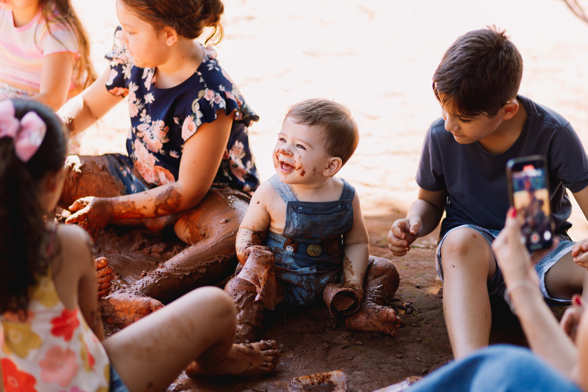 festa de 1 ano de menino tema fazendinha do bita criança de botina brincando na terra