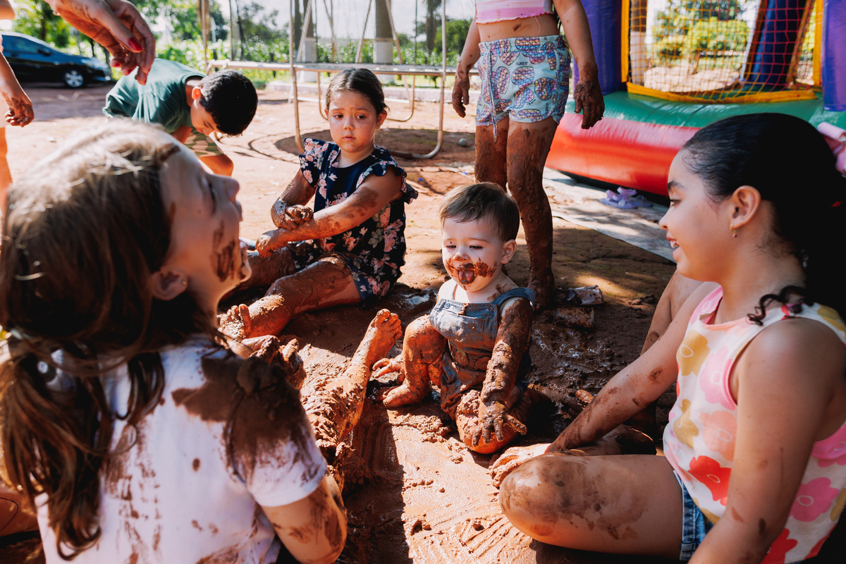 festa de 1 ano de menino tema fazendinha do bita criança de botina brincando na terra