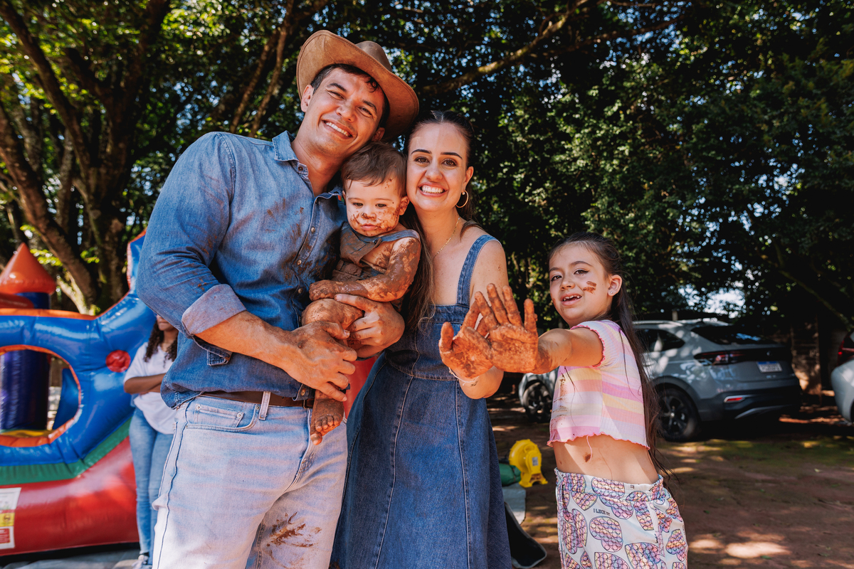 festa de 1 ano de menino tema fazendinha do bita criança de botina brincando na terra