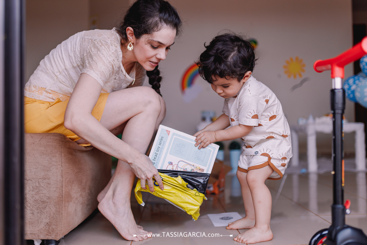 festa de 2 anos em casa com o tema céu, decoração feita pela mãe criança abrindo presente do mercado livre