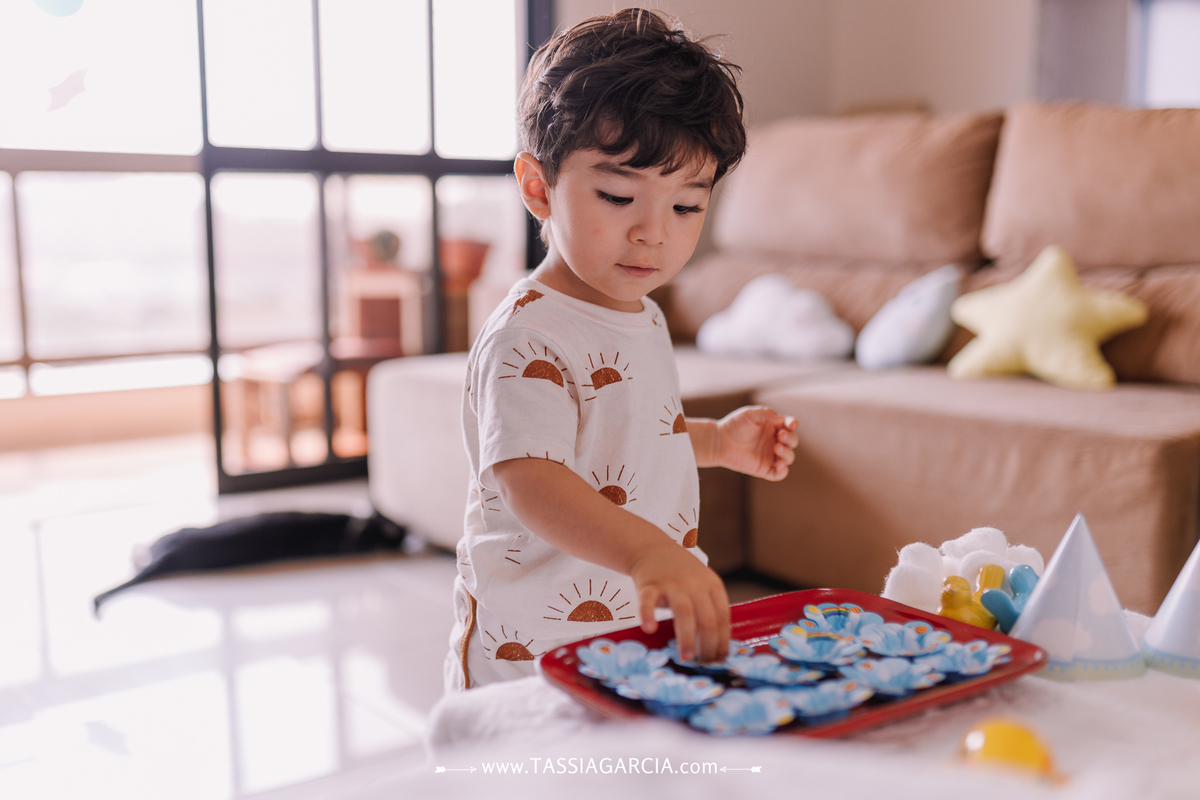 festa em casa com o tema céu, decoração feita pela mãe criança arrumando a mesa