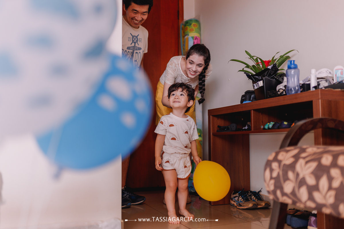 criança vendo a decoração da festa com balão na mão