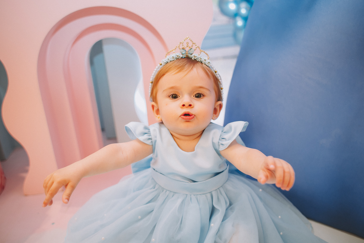 Aniversariante de 1 ano sorrindo e explorando a festa, em um momento leve e divertido