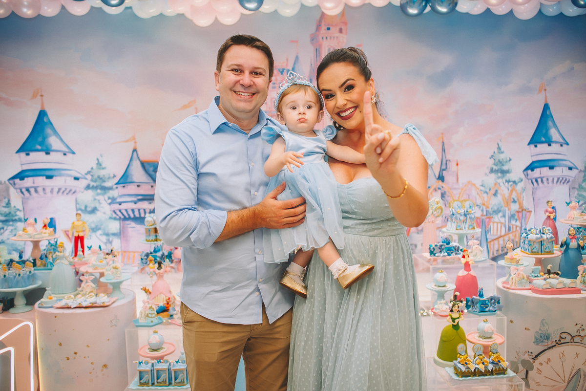 Família reunida celebrando o primeiro aninho da Maria Vitória, com momentos de carinho e diversão entre pais e filha