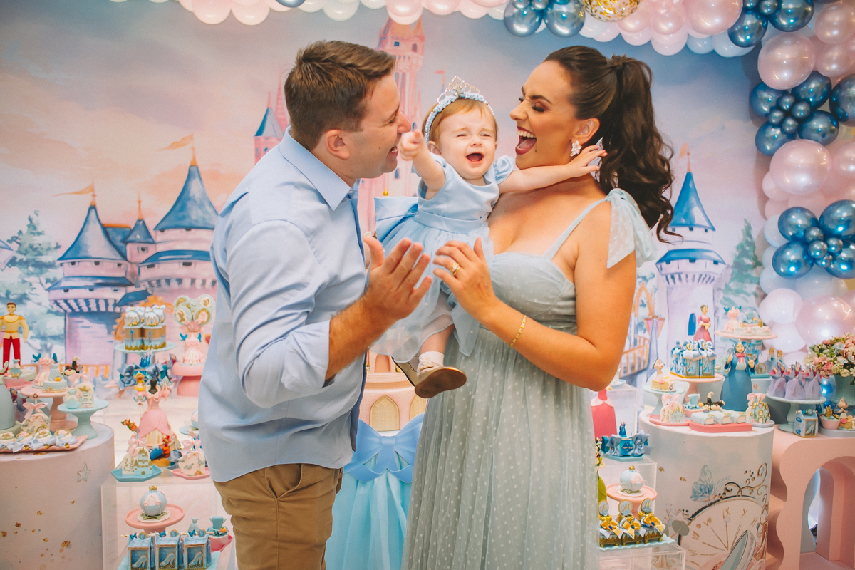 Família reunida celebrando o primeiro aninho da Maria Vitória, com momentos de carinho e diversão entre pais e filha