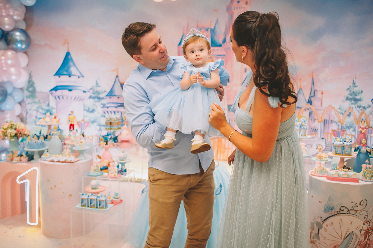 Família reunida celebrando o primeiro aninho da Maria Vitória, com momentos de carinho e diversão entre pais e filha