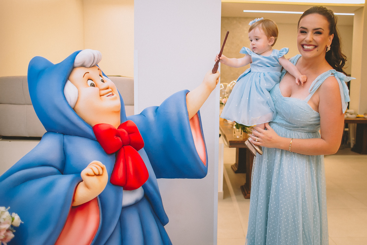 Pais brincando e aproveitando a festa com a filha no seu primeiro aniversário