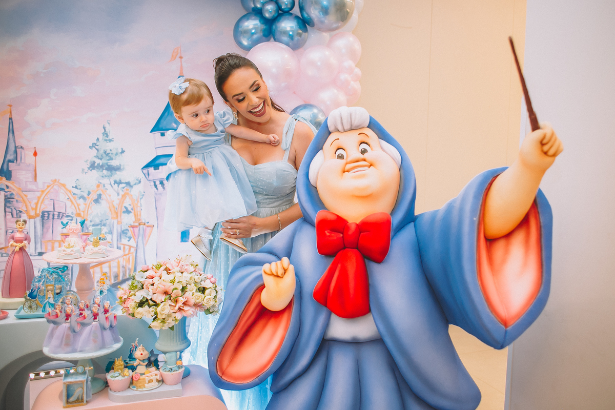 Pais brincando e aproveitando a festa com a filha no seu primeiro aniversário