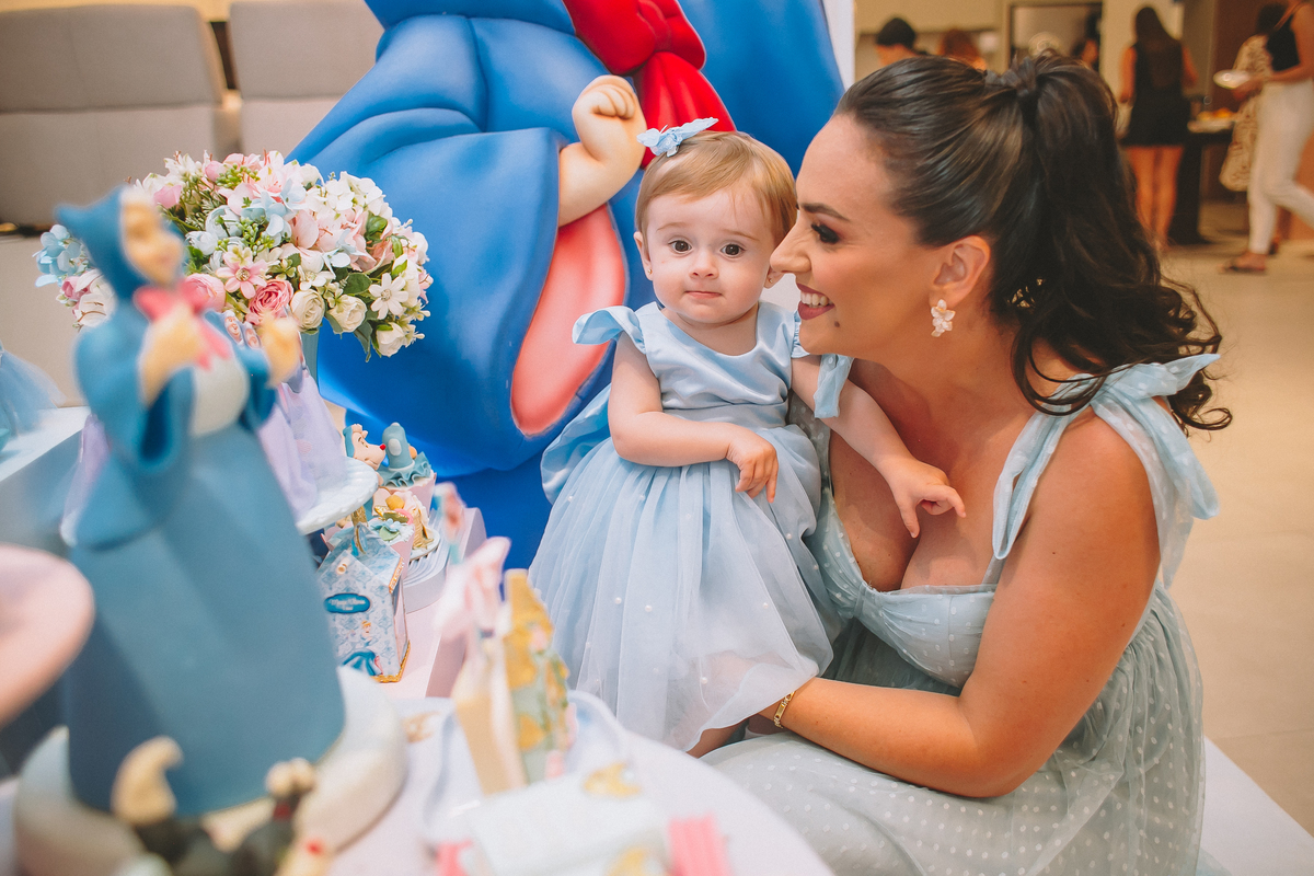 Pais brincando e aproveitando a festa com a filha no seu primeiro aniversário