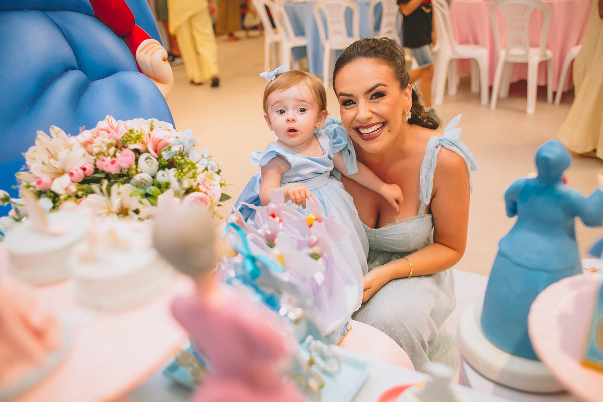Pais brincando e aproveitando a festa com a filha no seu primeiro aniversário