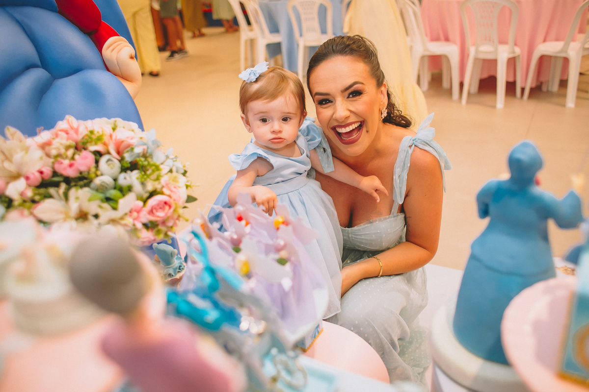 Pais brincando e aproveitando a festa com a filha no seu primeiro aniversário