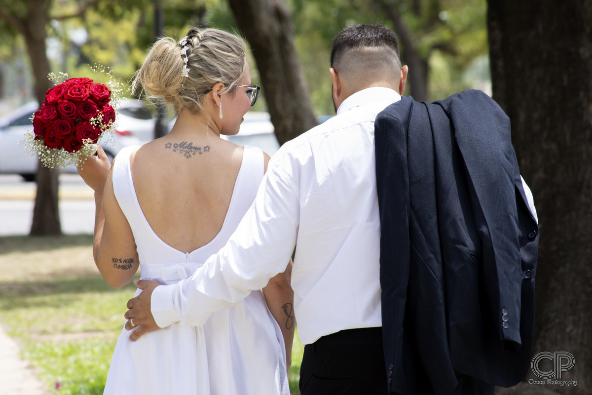 bodas en rosario, argentina, fotos con el ramo de novia de rosas rojas al aire libre, pareja de novios en sesion de fotos