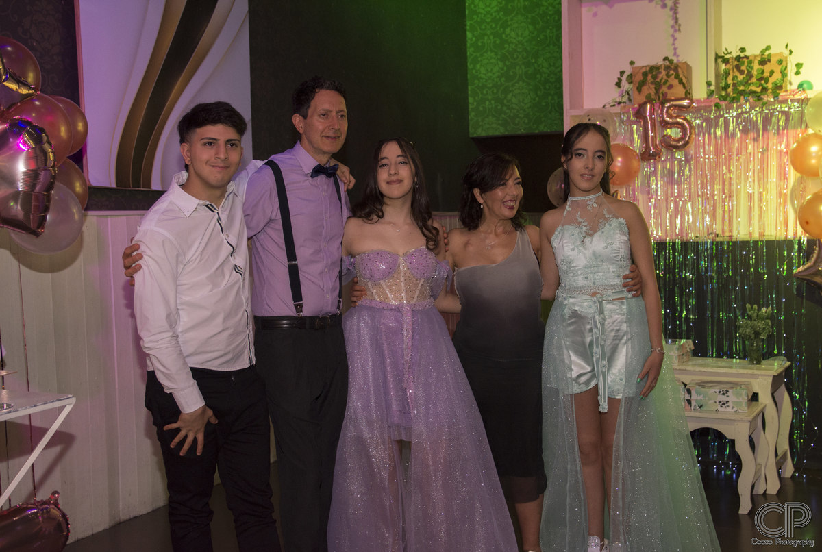 fotografía familiar en salón de fiestas festejando los 15 años de  hermanas mellizas