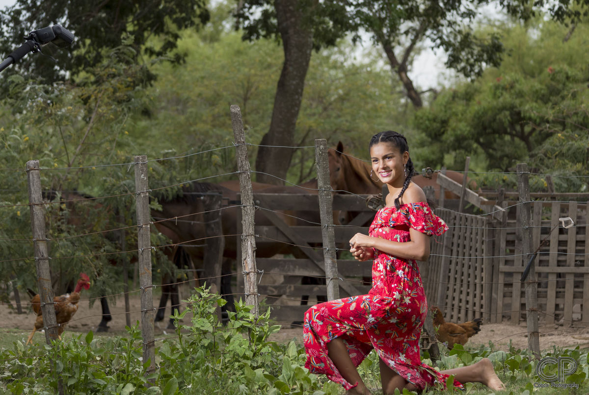 fotos previas a la fiesta de 15 años en las islas con vestido rojo al aire libre en una granja y con caballos en rosario