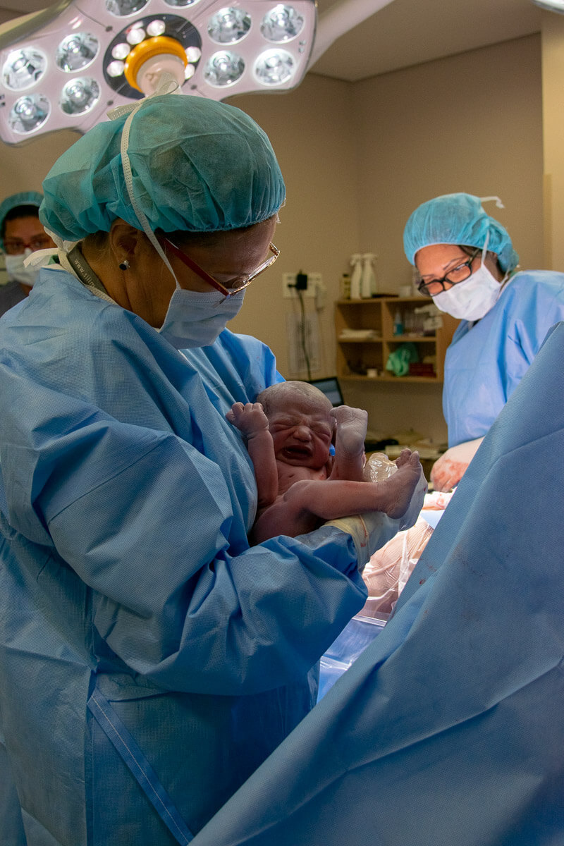 Fotografia documental de parto / Fotografa de parto - nascimento do filho. O bebê recém nascido chorando no colo da médica