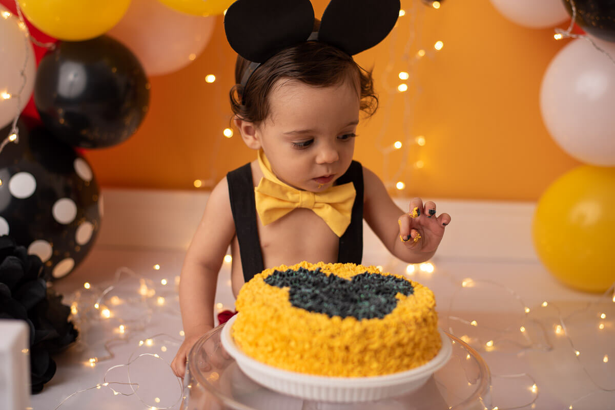 Ensaio acompanhamento bebe de smash the cake do mickey e splash no estúdio Dany Mathias Fotografia. Começou a bagunça! O que é isto na minha mão? Acho que o bebe vai gostar e se divertir muito. Será que estou certa?