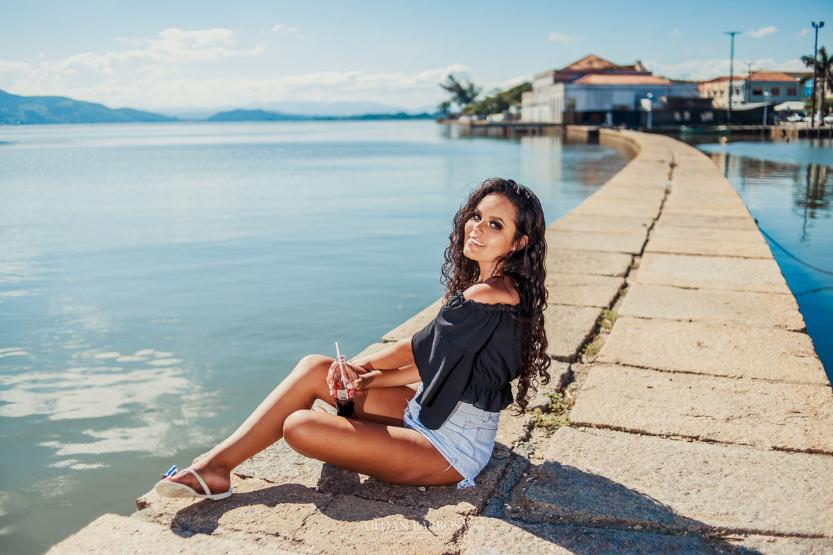 ensaio externo de 15 anos de gêmeas feito em laguna, na cidade histórica e na praia com coca cola