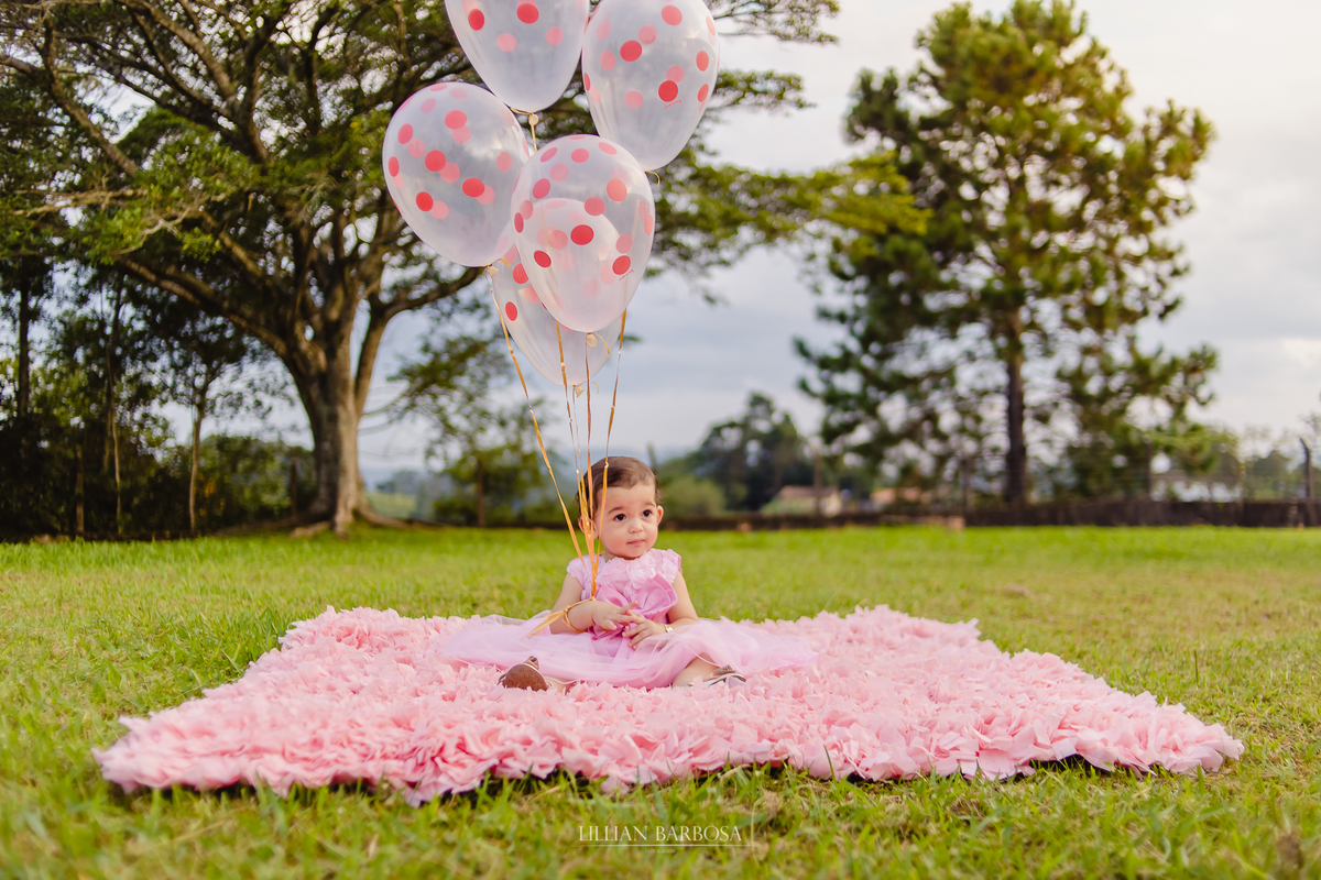 aniversário infantil de um ano de menina, jardim encantado, menina com vestido rosa com balões flutuantes