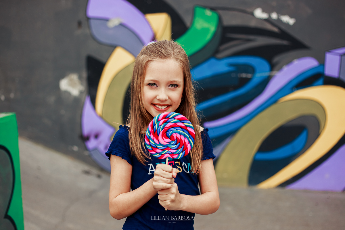 ensaio fotografico de 9 anos de menina - julia fez nove anos com book em lauro muller fotografa lillian barbosa fotos com pirulito em muro colorido