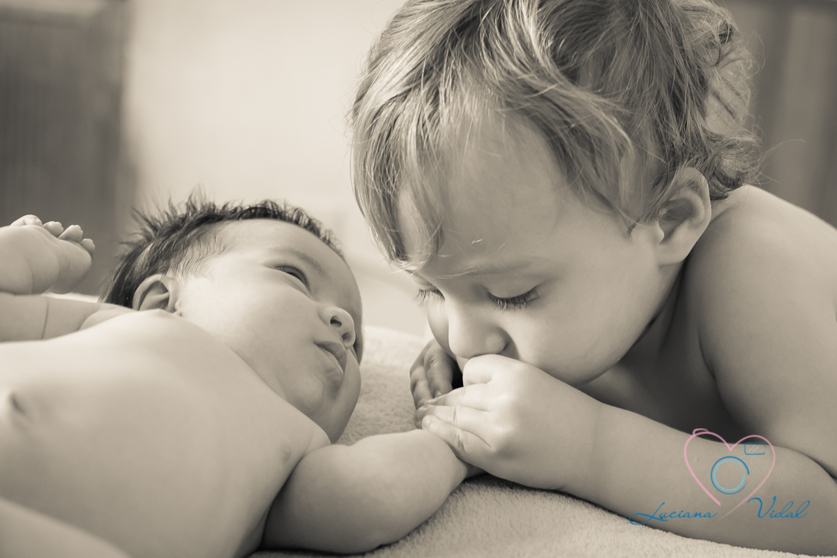Ensaio Newborn Lara, com 19 dias, fotografia Luciana Vidal em São Paulo, imagem com a presença do pequeno Henrique dando um beijo doce na mão da Lara.