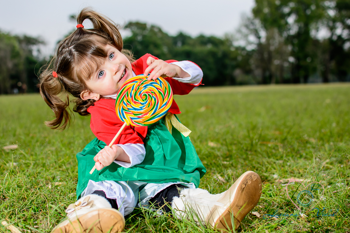 Fotografia Luciana Vidal, ensaio família, foto no parque, fotos de família, no parque Ibirapuera, em São Paulo, SP de chiquinha com seu pirulito.