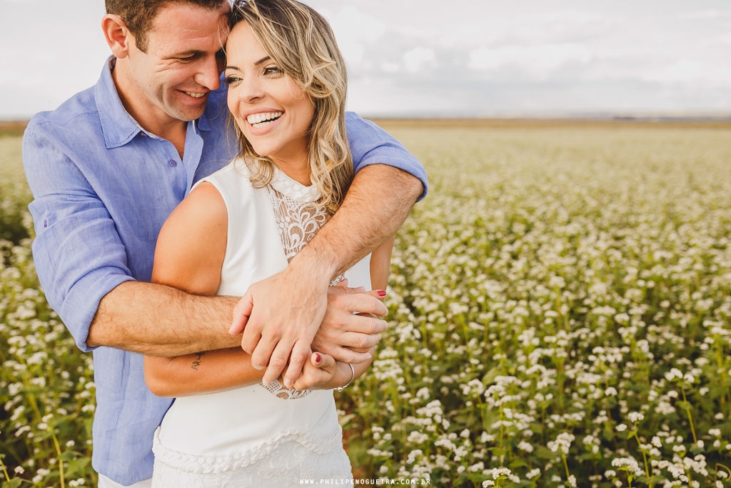 Ensaio de casal em Brasília - DF com os noivos sorrindo em campo de trigo pelo fotógrafo profissional de casamentos Philipe Nogueira