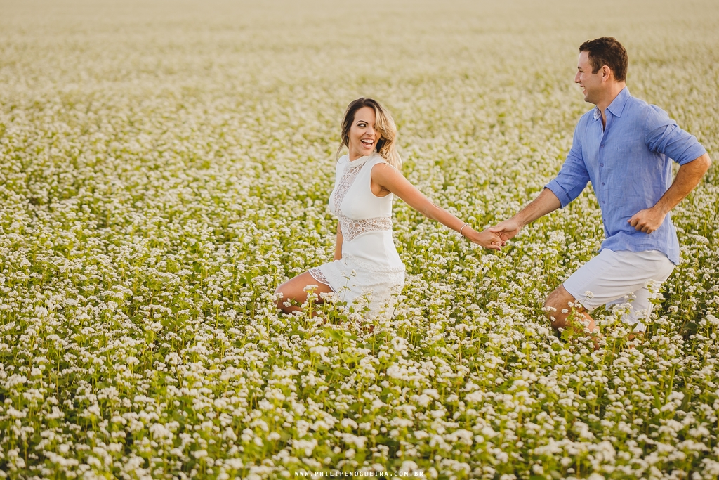 A noiva leva o noivo pela mão em ensaio no campo plantação Brasília Df
