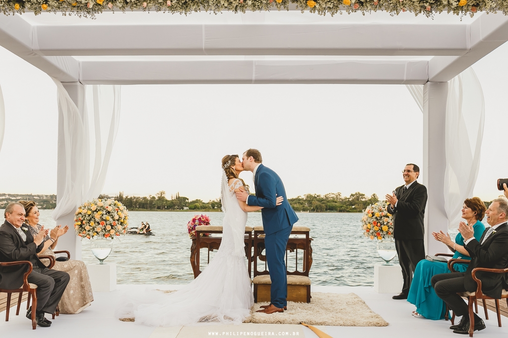 Casal de noivos se beija na cerimônia ao ar livre no salão de festas Porto Vitoria em fotografia profissional de casamento Brasília Df pelo fotógrafo profissional Philipe Nogueira