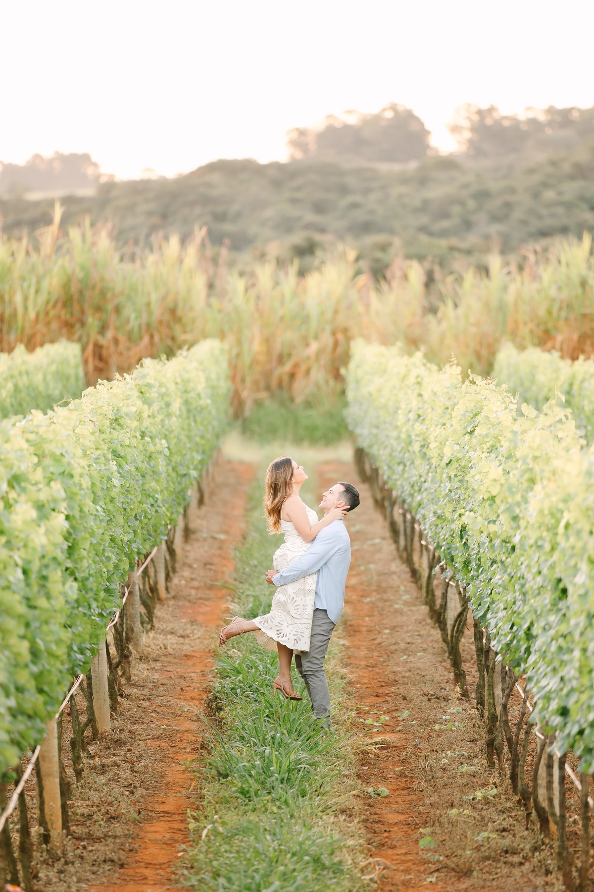 Ensaio de casal na Vinícola Casa Vitor, próximo a Brasília. Fotos da Marcella e do Henrique entre vinhedos, com luz natural e clima romântico. Fotografia de casal com estilo autoral, leve e espontâneo, em cenário elegante e diferente do tradicional.