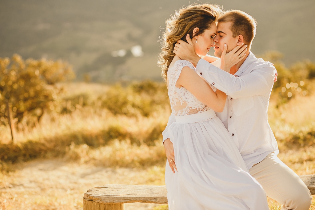 O casal se beija em Pirenópolis Go com os namorados sentados em mirante pelo fotógrafo profissional de casamentos Philipe Nogueira