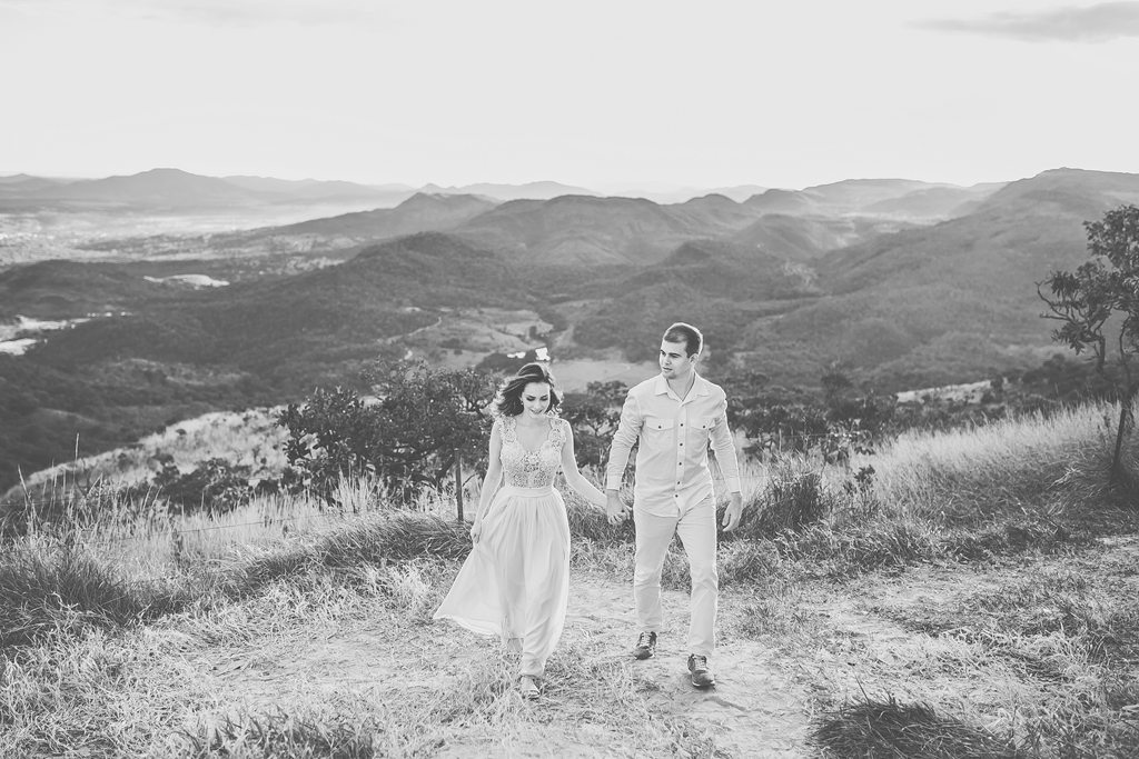 O casal caminha em fotografia preto e branca tirada pelo fotógrafo profissional de casamentos no ensaio de namorados no mirantre em Pirenópolis Go