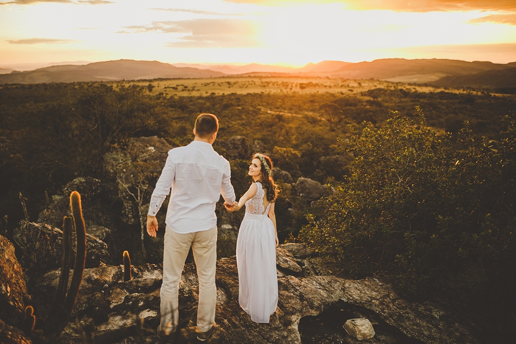 A noiva leva o noivo pela mão em ensaio no por do sol Pirenópolis Go
