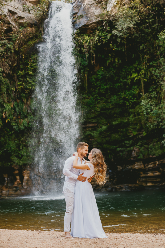 No ensaio noivos o casal se beija na cachoeira do Abade