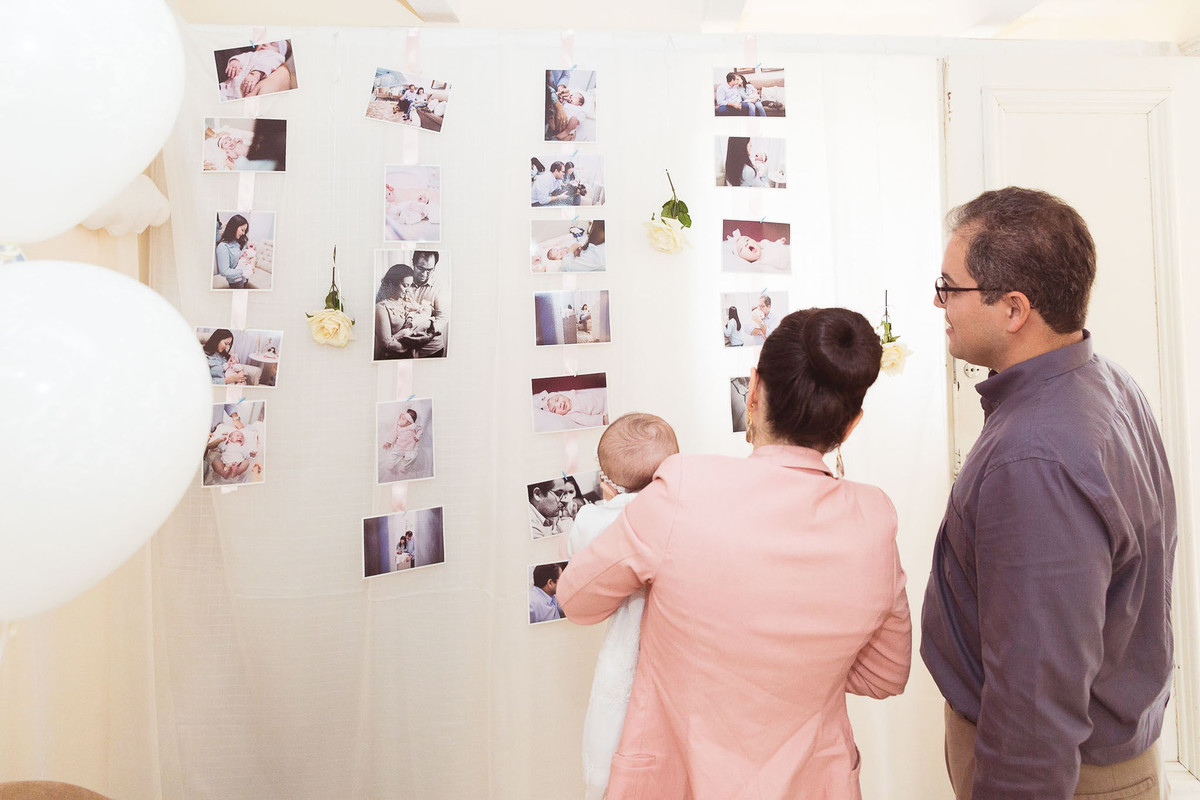 Olhando fotos. Batizado Maria Laura. Casa de Eventos Bela Aliança. Fotografia de Eduardo Pasqualini, fotógrafo em Rio do Sul, Santa Catarina.