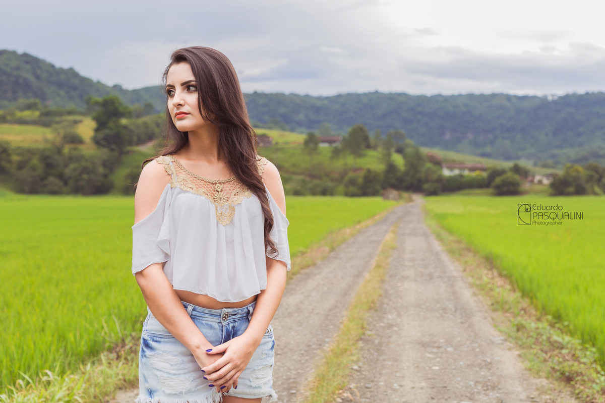 Bela jovem em área rural em meio a plantação de arroz. Fotografia de Eduardo Pasqualini, fotógrafo de casamentos e ensaios em Rio do Sul, Santa Catarina.