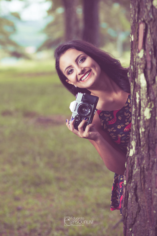 Com uma câmera em mãos, Aline brinca feliz. Fotografia de Eduardo Pasqualini, fotógrafo de casamentos e ensaios em Rio do Sul, Santa Catarina.