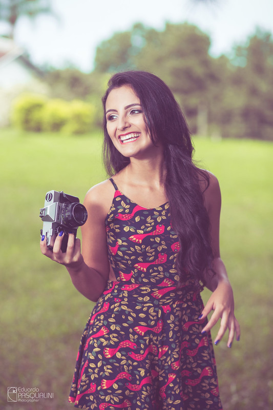 Linda e feliz, Aline segura câmera antiga em seu ensaio fotográfico. Fotografia de Eduardo Pasqualini, fotógrafo de casamentos e ensaios em Rio do Sul, Santa Catarina.