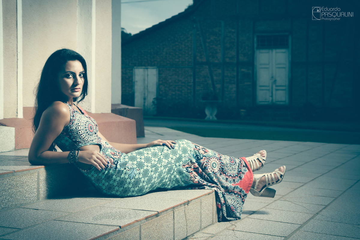 Foto com tratamento Vintage da modelo Aline deitada próxima a casa germânica. Fotografia de Eduardo Pasqualini, fotógrafo de casamentos e ensaios em Rio do Sul, Santa Catarina.