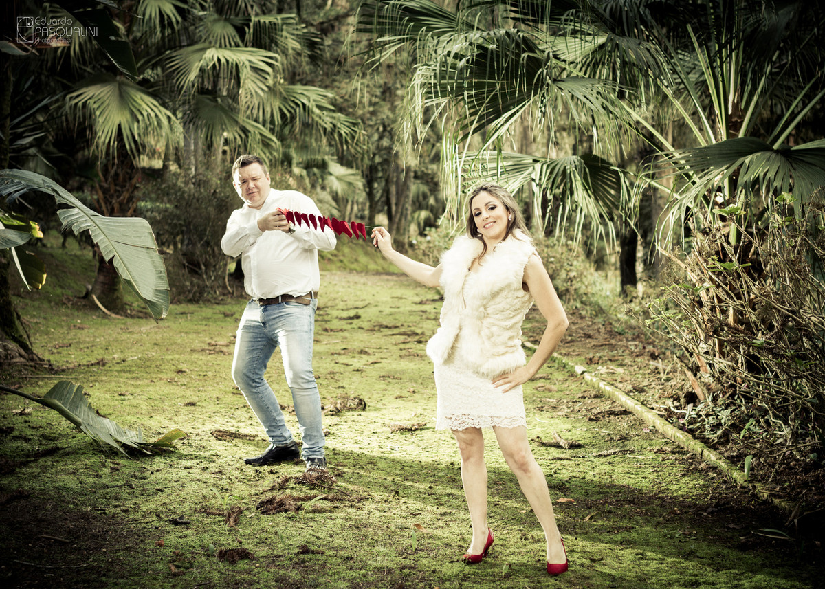 Noivo puxando fita de corações. Fotografia de Eduardo Pasqualini, fotógrafo de casamentos e ensaios em Rio do Sul, Santa Catarina.
