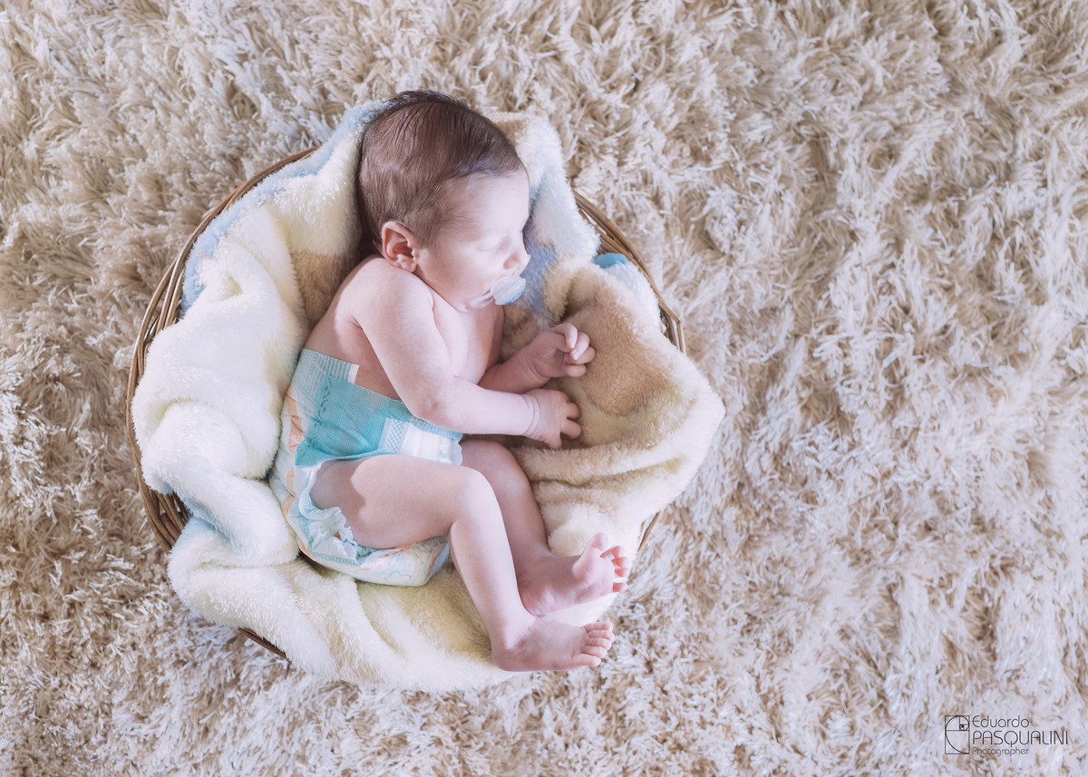 Bebê com apenas 15 dias dormindo em cesto de vime. Fotografia de Eduardo Pasqualini, fotógrafo de casamentos e ensaios em Rio do Sul, Santa Catarina.