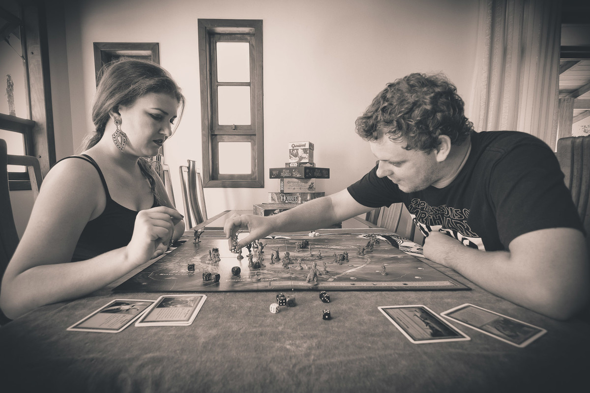 Jogando jogos de mesa, casal em ensaio pre-wedding. Fotografia de Eduardo Pasqualini Fotógrafo profissional de ensaio e casamento em Rio do Sul, Santa Catarina, Brasil.