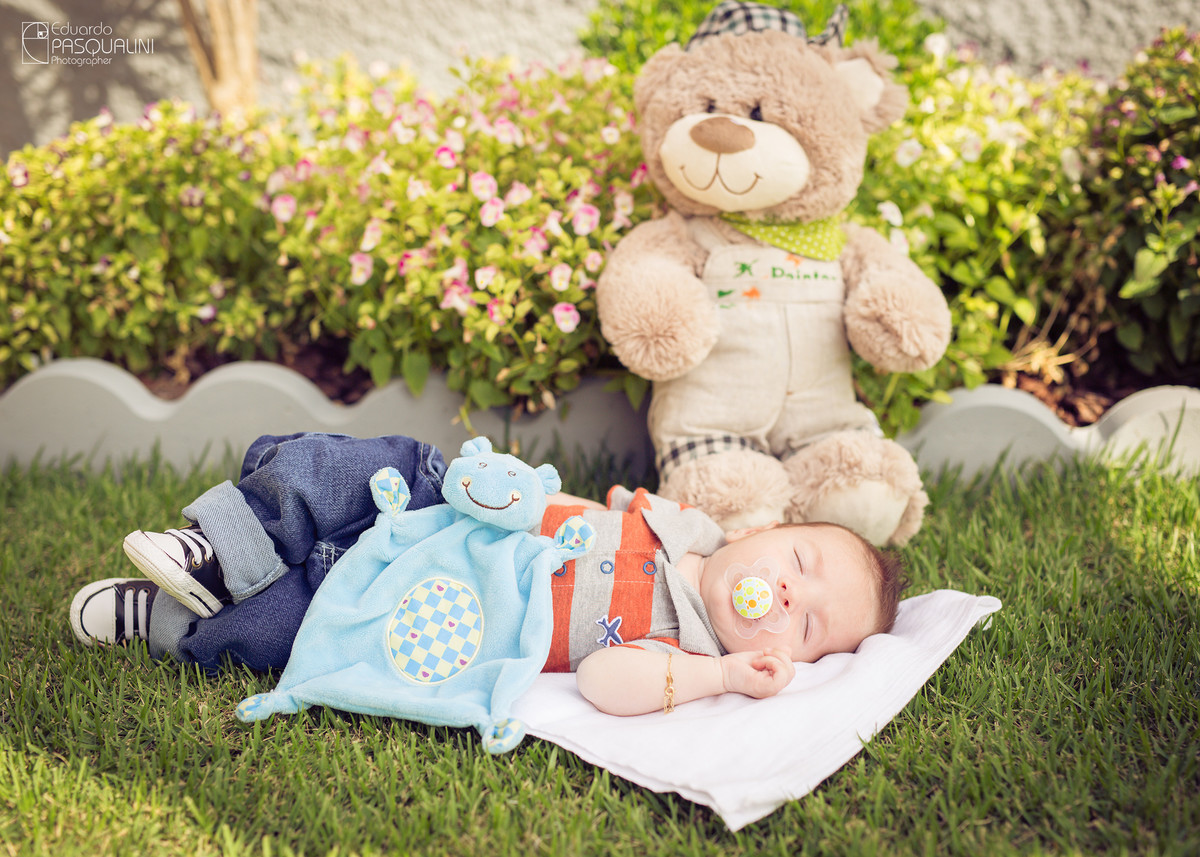 Junto de seu cheirinho e ursinho de pelúcia, bebê dorme feliz. Fotografia de Eduardo Pasqualini, fotógrafo de casamentos e ensaios em Rio do Sul, Santa Catarina.