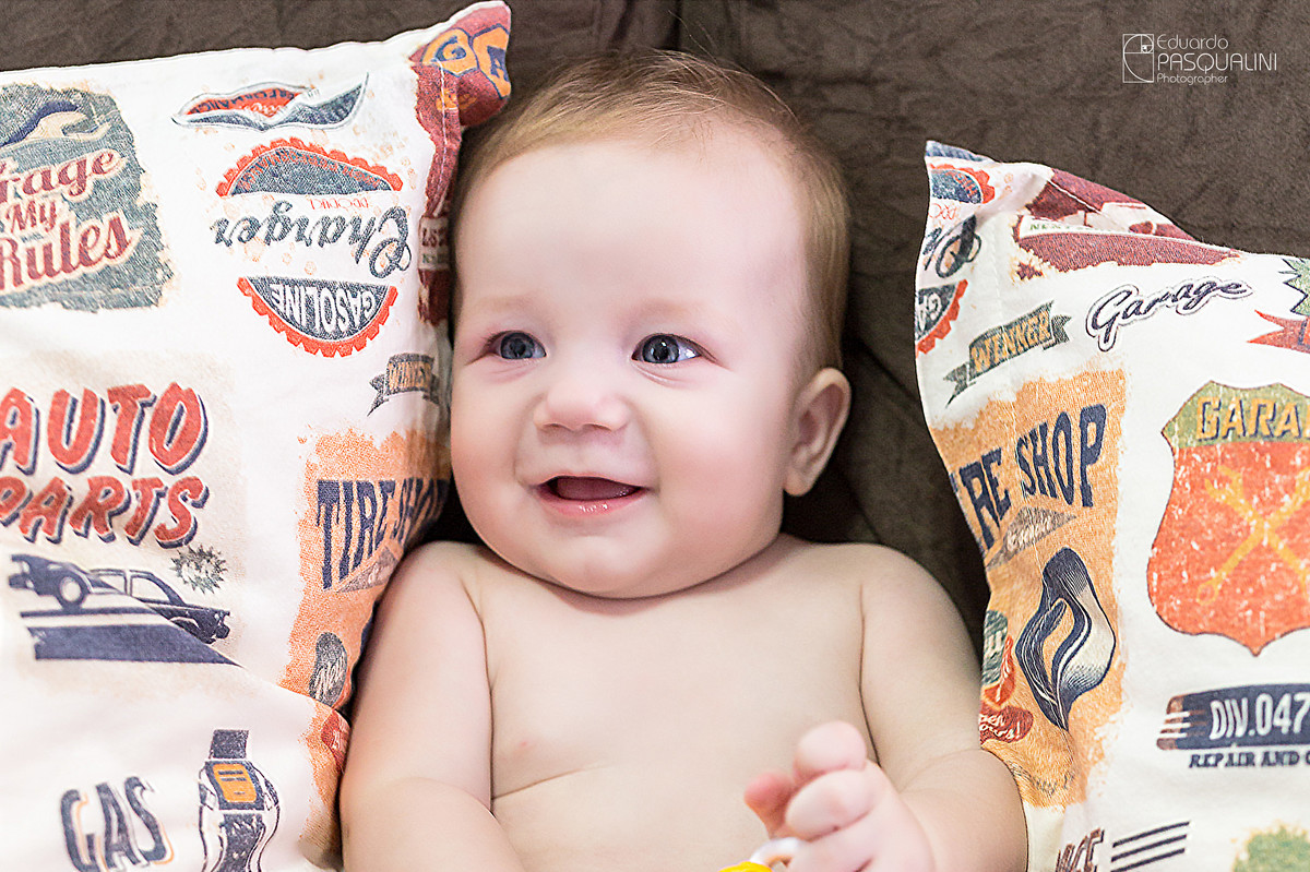 Sorrisinho engraçadinho de criança bebê. Fotografia de Eduardo Pasqualini, fotógrafo de casamentos e ensaios em Rio do Sul, Santa Catarina.