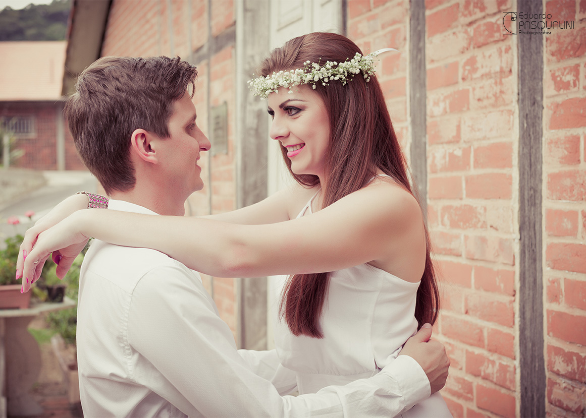 Com coroa de pequenas flores, Tamires abraça Cleber. Fotografia de Eduardo Pasqualini, fotógrafo de casamentos e ensaios em Rio do Sul, Santa Catarina.
