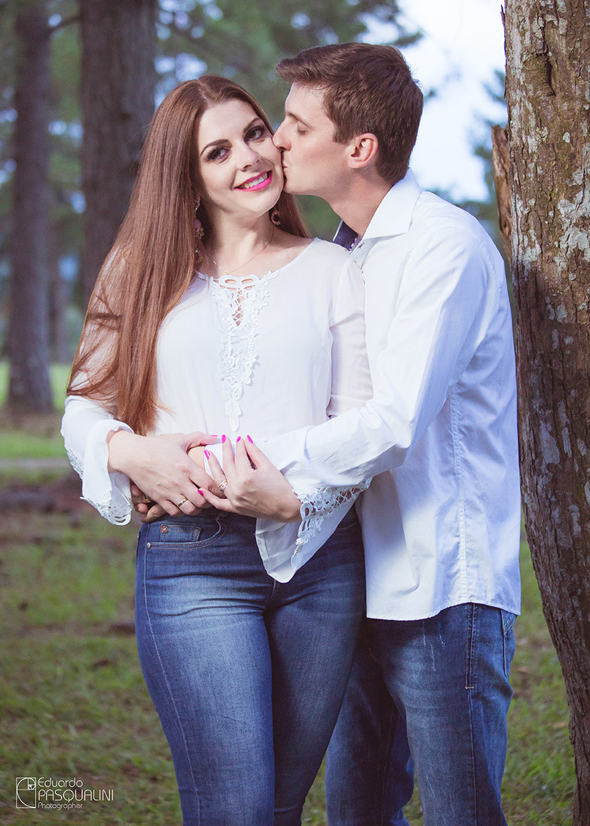 Beijando rosto de noiva, que sorri para câmera. Fotografia de Eduardo Pasqualini, fotógrafo de casamentos e ensaios em Rio do Sul, Santa Catarina.