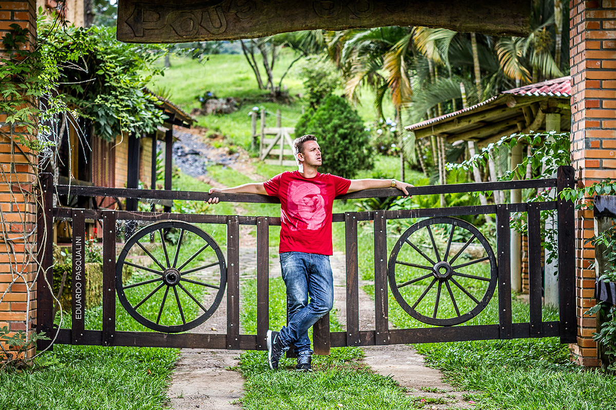 Homem apoiado em porteira, portão de sítio. Foto de Eduardo Pasqualini, fotógrafo de casamentos e ensaios em Rio do Sul, Santa Catarina.