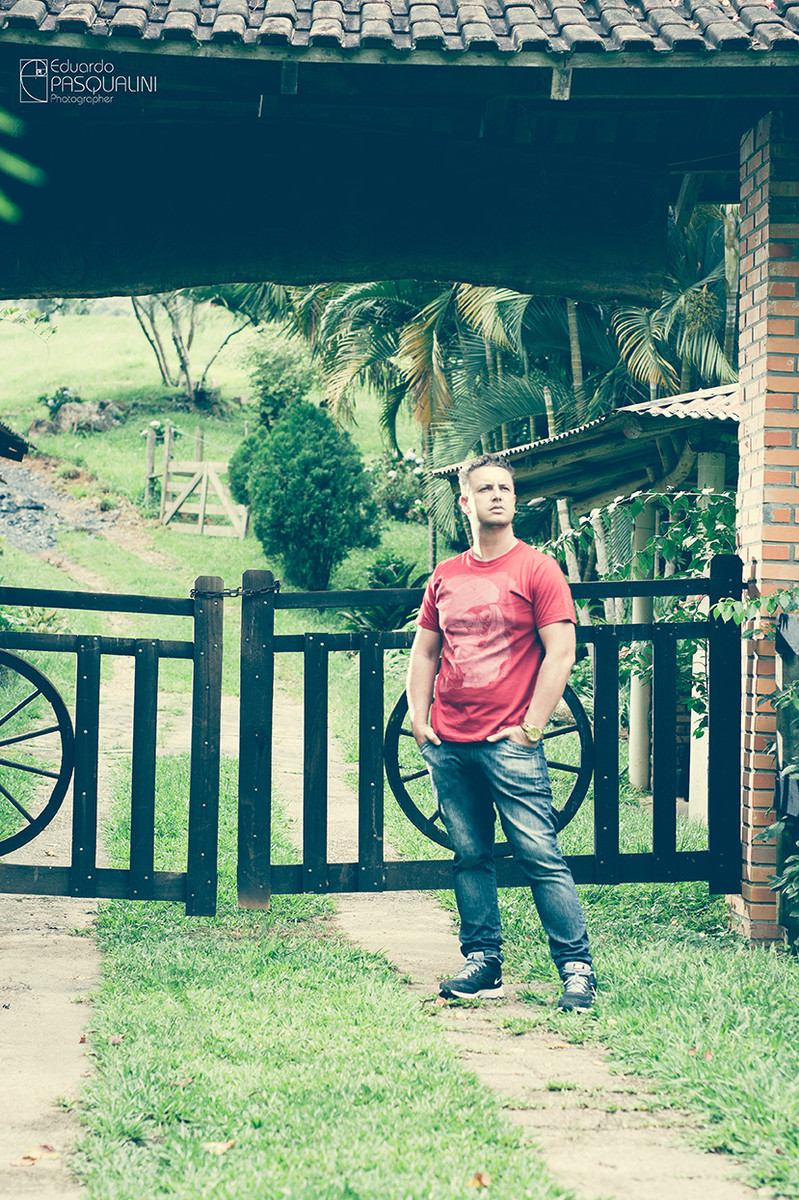 Homem em frente porteira, portão de sítio com as mãos no bolso. Foto de Eduardo Pasqualini, fotógrafo de casamentos e ensaios em Rio do Sul, Santa Catarina.